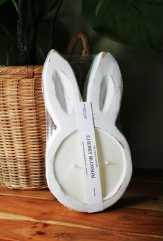 a white rabbit shaped candle holder next to a wicker basket