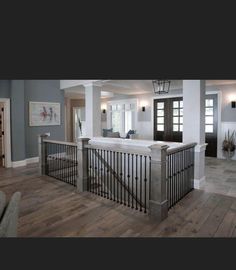 a large open concept living room with wood flooring and white walls, along with an entry way leading to the kitchen