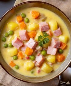 a bowl filled with ham, potatoes and peas