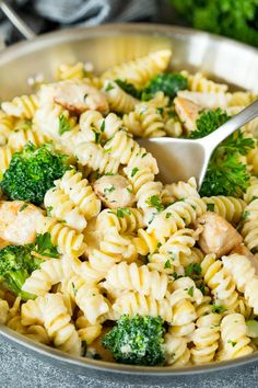 a bowl full of pasta with broccoli and chicken