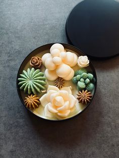 a bowl filled with different types of fake flowers