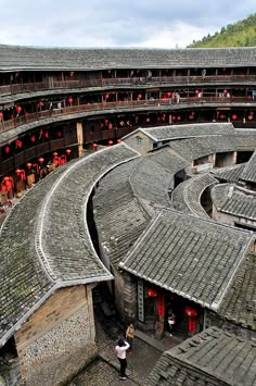 an aerial view of a circular building with people standing in the doorways and onlookers