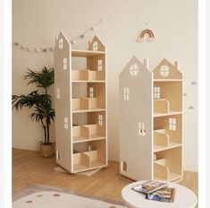 two wooden doll houses sitting on top of a hard wood floor