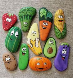 painted rocks with vegetables and faces on them are arranged in the shape of fruits and vegetables