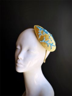 This chic headpiece features a teardrop-shaped base in a rich golden hue, beautifully adorned with blue floral lace and delicate beadwork. Ideal for weddings, garden parties, and tea parties, this fascinator add charm to any outfit. Age Group/Gender - Adult/Women Size/Type - One size fits all adults Color - Gold/Blue Material - Velvet and beaded lace fabric Special Features - Floral lace design Unique Wedding Crown Headpiece, Adjustable Teardrop Crown Headpiece For Party, Adjustable Teardrop Crown Costume Hat For Parties, Elegant Gold Mini Hats For Gifts, Elegant Gold Mini Hats For Gift, Handmade Fascinator As Gift, Blue Headpiece For Party, Adjustable Gold Headpieces For Ceremonies, Handmade Crown Costume Hat For Weddings