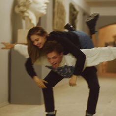 a man riding on the back of a skateboard next to a woman