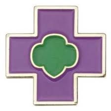 a purple and green cross with four leaf clovers on the center, in front of a white background