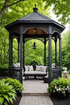 a black gazebo sitting in the middle of a lush green park