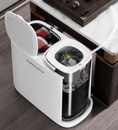 an automatic coffee maker with two cups in it's storage compartment on the floor