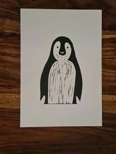 a black and white drawing of a penguin on a piece of paper with woodgrain