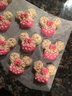 mickey mouse cookies with pink frosting and bows on them are ready to be eaten