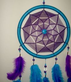 a purple and blue dream catcher hanging on the wall