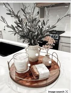 a tray with candles and flowers on top of a kitchen counter