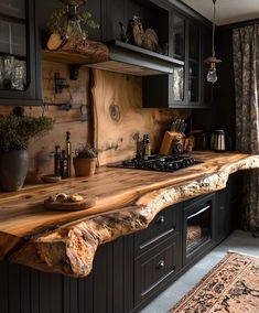 a kitchen with black cabinets and wooden counter tops, an area rug and potted plants