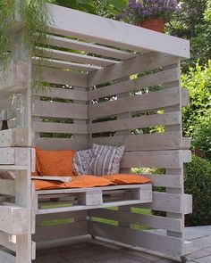 a bench made out of wooden pallets with an orange pillow on it's seat