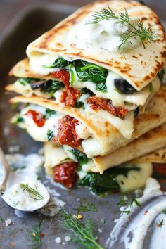 three quesadillas stacked on top of each other with sauce and herbs in the middle