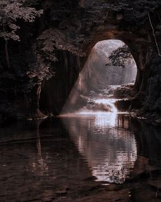 the light shines through an opening in the rock formation that is reflected in the water