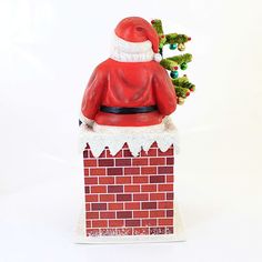 a santa clause sitting on top of a brick chimney