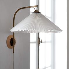 a white lamp hanging from the side of a wall