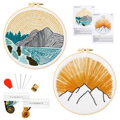 two embroidery kits with mountains and trees in the background, including an orange sunburst