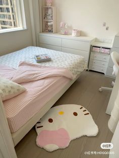 a bedroom with a hello kitty rug on the floor next to a bed and dresser