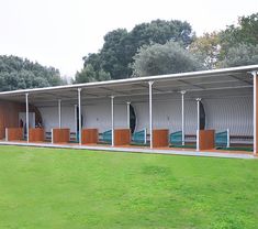 an empty building with wooden doors in the grass