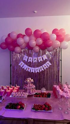 a table topped with lots of desserts and balloons