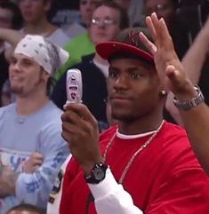 a man holding up his cell phone in front of an audience