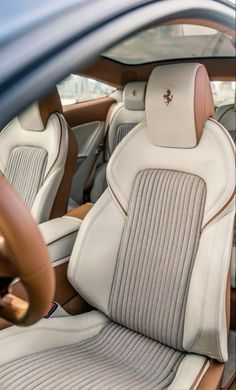 the interior of a car with beige and white leather