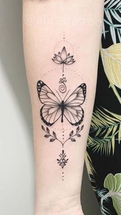 a black and white butterfly tattoo on the right leg, with an intricate design in the middle