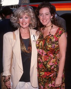 two women standing next to each other at an event