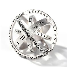 a silver ring with words and symbols on it's center, sitting in front of a white background