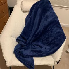 a white chair with a blue blanket on it