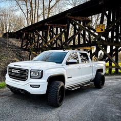 a white truck parked in front of a wooden structure