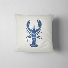 a blue lobster pillow sitting on top of a white wall