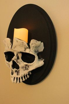 a skull mounted on the wall with a candle