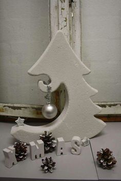 a white christmas tree with ornaments around it