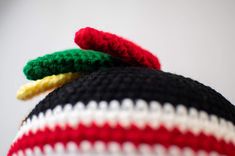 there is a knitted hat with a green, white and red stripe on it