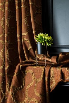 a potted plant sitting on top of a window sill next to a curtain