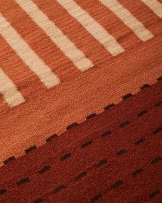 an orange and white rug with black dots on it's edges is seen in this image