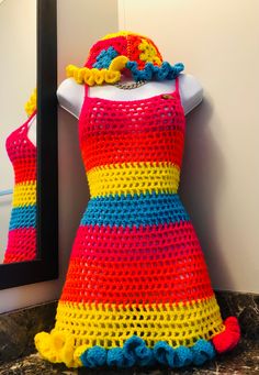 a crocheted dress is displayed in front of a mirror