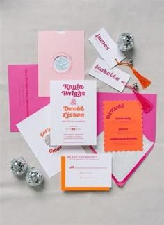 the wedding stationery is laid out on top of each other, including cards and candy