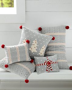 christmas pillows on a white bench with red pom - poms around the edges