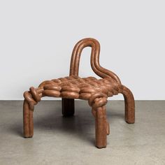 a wooden chair made out of pipes on concrete