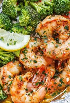 cooked shrimp and broccoli on foil with lemon wedged garnishes