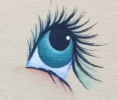 an eye painted on the side of a wall with long black hair and blue eyes