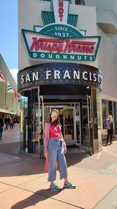 a woman standing in front of a restaurant called sanfrancisco with her eyes closed