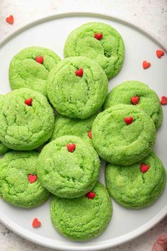 green cookies with red hearts on a white plate