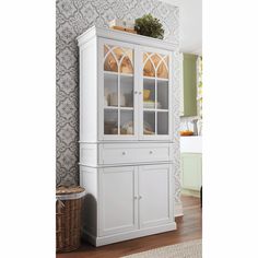 a white china cabinet sitting on top of a hard wood floor next to a wall