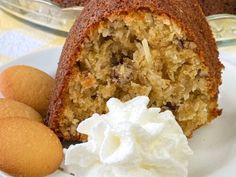 a bundt cake with whipped cream on a plate next to some cookies and marshmallows